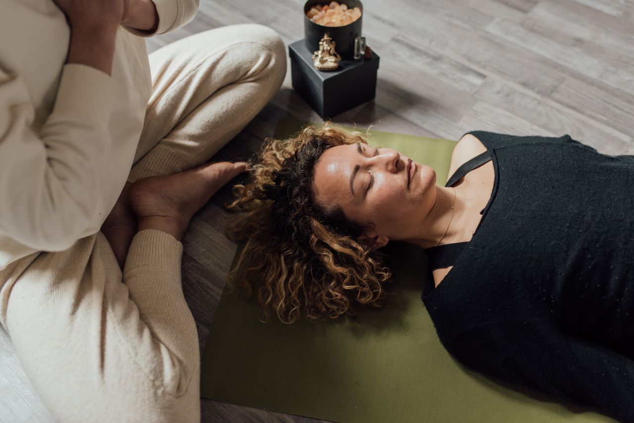 creative-02 A woman meditating indoors on a yoga mat in a calm atmosphere.