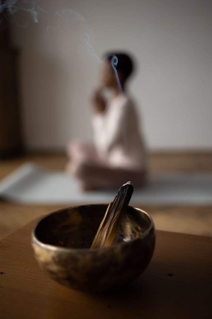 mobile-02 A serene moment of mindfulness featuring incense in a singing bowl during yoga practice.